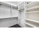 Walk-in closet with built-in shelving, hanging rods, and dark tile flooring at 1822 W Marlette Ave, Phoenix, AZ 85015