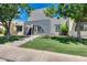 Two-story home with stone arched entrance, lush lawn, mature trees, and walkway to the front door at 1822 W Marlette Ave, Phoenix, AZ 85015