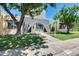 Front exterior of home featuring mature landscaping, lush lawn, stone archway, and large shade tree at 1822 W Marlette Ave, Phoenix, AZ 85015