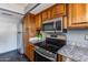 A modern kitchen featuring stainless steel appliances and granite countertops at 1822 W Marlette Ave, Phoenix, AZ 85015