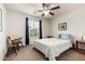 This cozy bedroom features carpet floors, a ceiling fan, and natural light from the large window at 20565 W Terrace Ln, Buckeye, AZ 85396