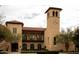Elegant exterior of the community center, featuring a clock tower, balconies, and lush landscaping at 20565 W Terrace Ln, Buckeye, AZ 85396