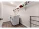 Efficient laundry room featuring modern washer/dryer units, storage shelves, and tile flooring at 20565 W Terrace Ln, Buckeye, AZ 85396