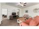 Cozy living room featuring stylish seating, a decorative ceiling fan, and warm wood-look tile flooring at 20565 W Terrace Ln, Buckeye, AZ 85396