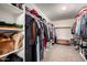 A large walk-in closet features built-in shelving units, carpet floors, and ample storage space at 20565 W Terrace Ln, Buckeye, AZ 85396