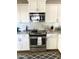Modern kitchen featuring stainless steel appliances, granite countertops, and white cabinetry at 2100 N Normal Ave, Tempe, AZ 85288