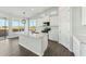 Modern kitchen features white cabinets, stylish lighting, and an island with bar seating at 22343 S Manzanilla Rd, Buckeye, AZ 85326