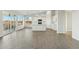 Bright, open-concept living space with hard surface floors and a kitchen featuring white cabinets at 22343 S Manzanilla Rd, Buckeye, AZ 85326