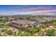 An aerial perspective showcases a fenced backyard with lush plants and a patio area, set against mountain views at 22515 E Sonoqui Blvd, Queen Creek, AZ 85142