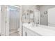 Clean bathroom with a white vanity, decorative mirror, and a view into the shower area at 22515 E Sonoqui Blvd, Queen Creek, AZ 85142