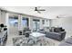 Bright living room with neutral gray tones, featuring a ceiling fan and sliding glass doors to the backyard pool at 22515 E Sonoqui Blvd, Queen Creek, AZ 85142