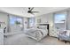 A well-lit bedroom featuring a ceiling fan, a cozy bed with patterned linens, and bright windows at 22515 E Sonoqui Blvd, Queen Creek, AZ 85142