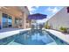 This sparkling pool features a tanning ledge and includes an umbrella and chairs for relaxing in the sun at 22515 E Sonoqui Blvd, Queen Creek, AZ 85142