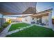 Spacious backyard featuring a covered patio, lush lawn, and outdoor cooking area at 2361 N 212Th Dr, Buckeye, AZ 85396