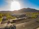 View of building exterior, parking lot, desert landscaping and mountain views in the background at 2361 N 212Th Dr, Buckeye, AZ 85396