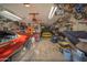 Spacious garage featuring a classic red car, a yellow car, motorcycle, ample storage and organized shelving at 2361 N 212Th Dr, Buckeye, AZ 85396