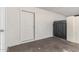 An open carport featuring a white door and dark metal gate to the backyard at 2508 N 58Th Ln, Phoenix, AZ 85035