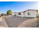 Street view of single-story home with white exterior, rock landscaping, and covered parking at 2508 N 58Th Ln, Phoenix, AZ 85035