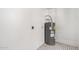 A utility room featuring a water heater and white brick walls above black and white tile floors at 2508 N 58Th Ln, Phoenix, AZ 85035
