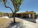 Private backyard featuring a covered patio, gravel landscape, and mature trees for shade and privacy at 2726 W Butler Dr, Phoenix, AZ 85051