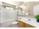 Bathroom featuring a glass-enclosed shower and tub, vanity with sink, and natural light for a refreshing feel at 3041 E Fremont Rd, Phoenix, AZ 85042