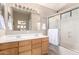 Bathroom features a double sink vanity, large mirror with modern lighting, and a shower-tub combination with sliding glass doors at 3041 E Fremont Rd, Phoenix, AZ 85042