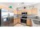 Well-equipped kitchen with stainless steel appliances, granite countertops, and light wood cabinetry at 3041 E Fremont Rd, Phoenix, AZ 85042