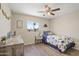 This cute bedroom has a wood dresser, twin bed, ceiling fan and a view of the community at 320 E Mckellips Rd # 46, Mesa, AZ 85201