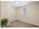 This bedroom has light tan walls, a light fixture, luxury vinyl floors, and a window at 320 E Mckellips Rd # 46, Mesa, AZ 85201