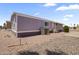 Exterior of a single-story gray home with an air conditioning unit and desert landscaping at 320 E Mckellips Rd # 46, Mesa, AZ 85201