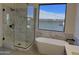 Bright bathroom featuring a modern glass shower and a freestanding tub under a large window at 33220 N 60Th Way, Scottsdale, AZ 85266