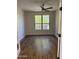 Empty bedroom featuring hardwood floors, a ceiling fan, and a window offering views of the outdoors at 33220 N 60Th Way, Scottsdale, AZ 85266