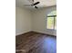 Bright bedroom featuring a ceiling fan, hardwood floors, and a large arched window at 33220 N 60Th Way, Scottsdale, AZ 85266
