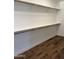 Walk-in closet with hardwood floors, white walls, and multiple racks for storage at 33220 N 60Th Way, Scottsdale, AZ 85266