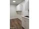 Practical laundry room with modern white cabinetry, countertop space, and wood-look flooring at 33220 N 60Th Way, Scottsdale, AZ 85266