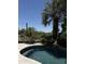 Beautiful pool area with desert landscaping, including palm trees, rock features, and serene waterfalls at 33220 N 60Th Way, Scottsdale, AZ 85266