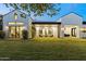 Spacious backyard featuring a covered patio, lush lawn, and modern farmhouse design at 3825 E Coolidge St, Phoenix, AZ 85018
