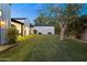 View of the spacious backyard of a well-maintained home with lush green grass and mature trees for shade at 3825 E Coolidge St, Phoenix, AZ 85018