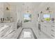 Elegant bathroom with marble floors, dual vanities, free-standing tub, and a separate glass-enclosed shower at 3825 E Coolidge St, Phoenix, AZ 85018