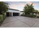 Modern home exterior with a large driveway and two-car garage featuring stylish black doors at 3825 E Coolidge St, Phoenix, AZ 85018