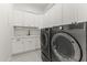 Well-equipped laundry room with modern washer and dryer, white cabinetry and neutral tiling at 3825 E Coolidge St, Phoenix, AZ 85018