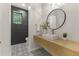 Modern powder room with designer tile, floating vanity, and stylish round mirror at 3825 E Coolidge St, Phoenix, AZ 85018
