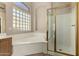 Bright bathroom with a glass block window, soaking tub, and glass-enclosed shower at 4010 E Hamblin Dr, Phoenix, AZ 85050