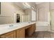 Bathroom featuring double sinks, a large mirror, a soaking tub, and a separate glass-enclosed shower at 4010 E Hamblin Dr, Phoenix, AZ 85050