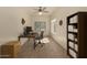 Home office featuring a sleek desk setup, built-in bookcase, and a contemporary ceiling fan at 4010 E Hamblin Dr, Phoenix, AZ 85050