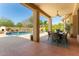 Covered patio with dining set overlooking a backyard featuring a pool and lush greenery at 4010 E Hamblin Dr, Phoenix, AZ 85050