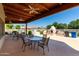 Community poolside patio with fireplace, barbeque area, outdoor seating, and covered wood ceiling at 4202 E Broadway Rd # 223, Mesa, AZ 85206