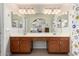 Bathroom featuring double vanity, and an expansive mirror, and an arched doorway to an adjacent bedroom at 5580 W Kesler St, Chandler, AZ 85226