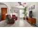 Cozy living room features tile floors, neutral walls, natural lighting, ceiling fan, and a large TV at 5580 W Kesler St, Chandler, AZ 85226