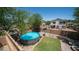 Aerial view of the backyard with a pool, grassy area, firepit with chairs, and a basketball hoop at 7274 W State Ave, Glendale, AZ 85303